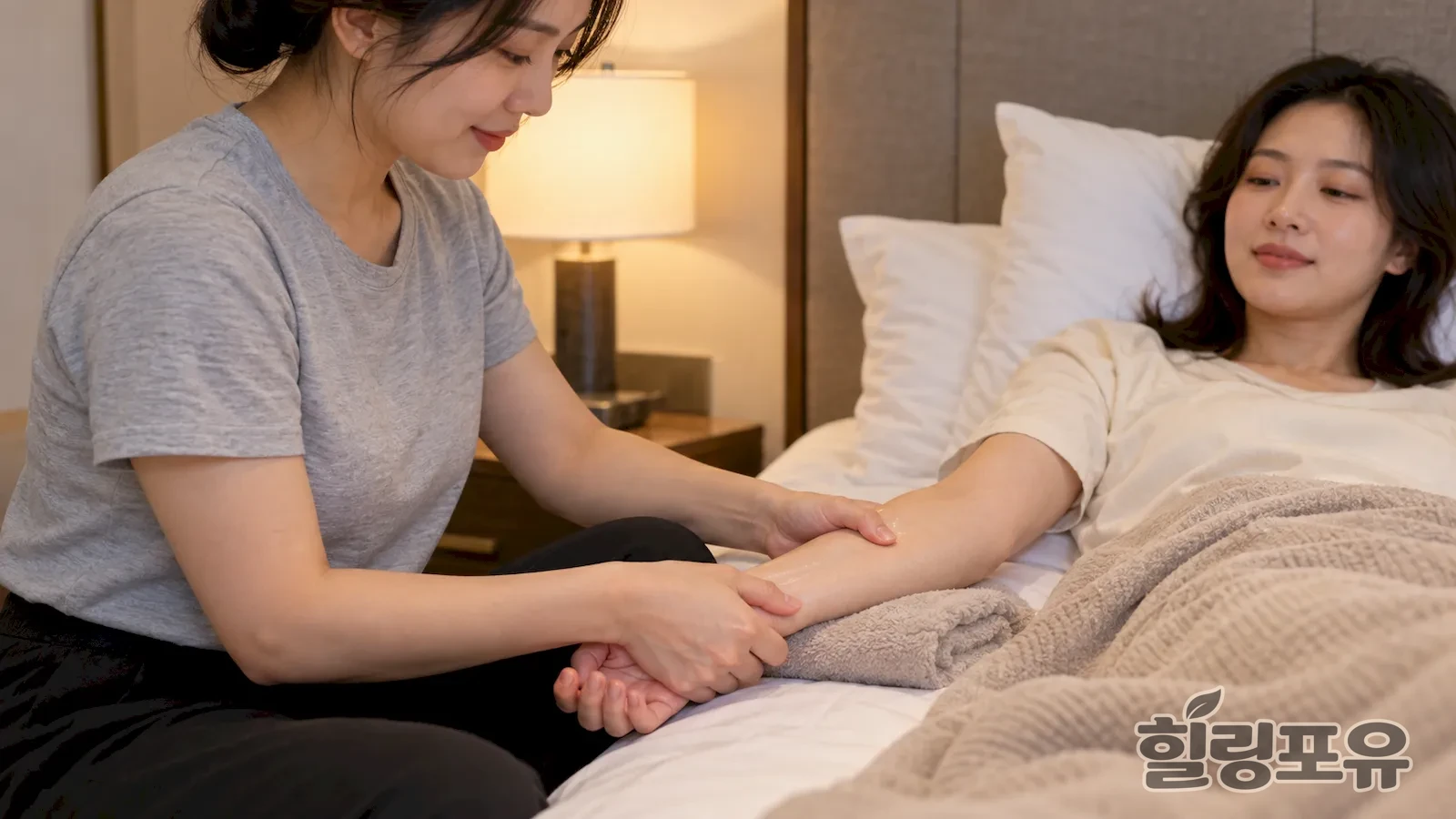침대에 누운 여성 고객의 팔을 관리하는 여성 관리사